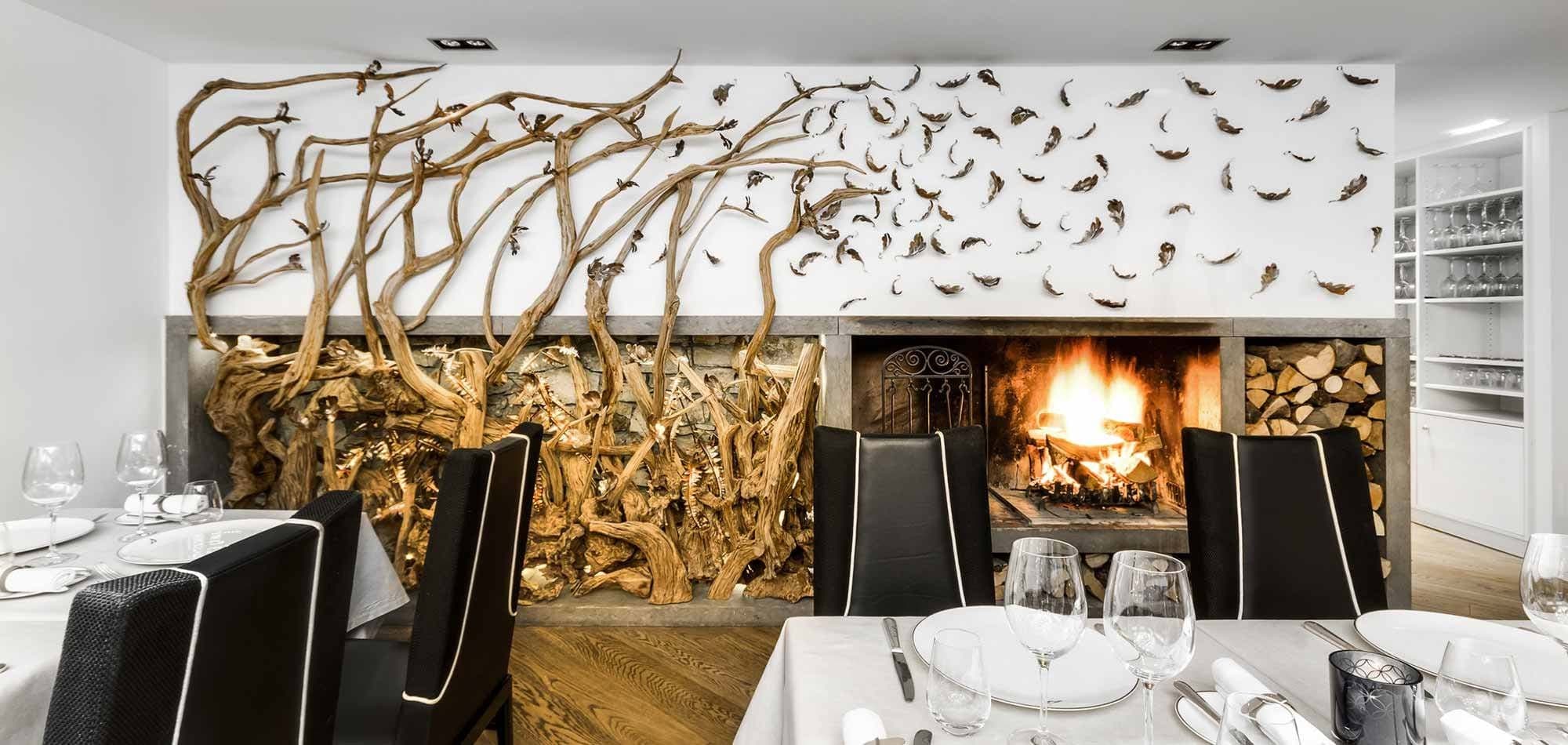 Dining area with wood-burning fireplace and custom root wall art