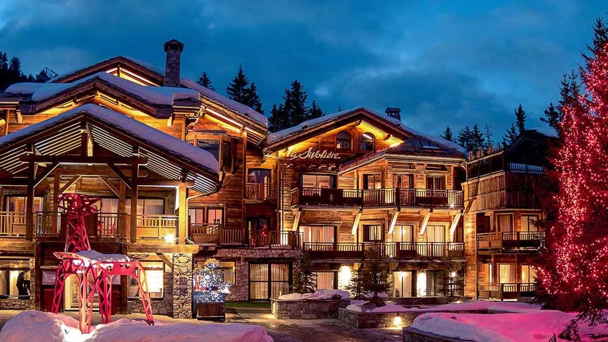 Chalet exterior with private balconies and stone-and-timber construction