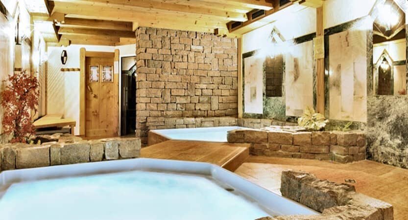 Indoor spa area featuring dual plunge pools and natural stone accents