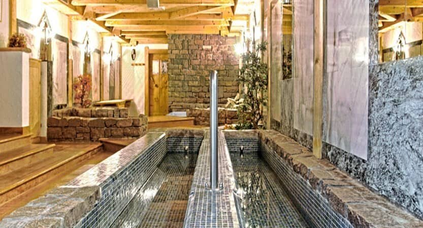 Indoor spa area featuring tiled Kneipp hydrotherapy foot baths