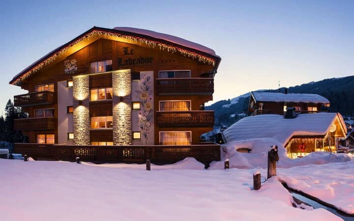 Chalet exterior at dusk with private balconies and mountain views