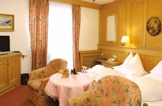 Guest bedroom with pine paneling and small seating area