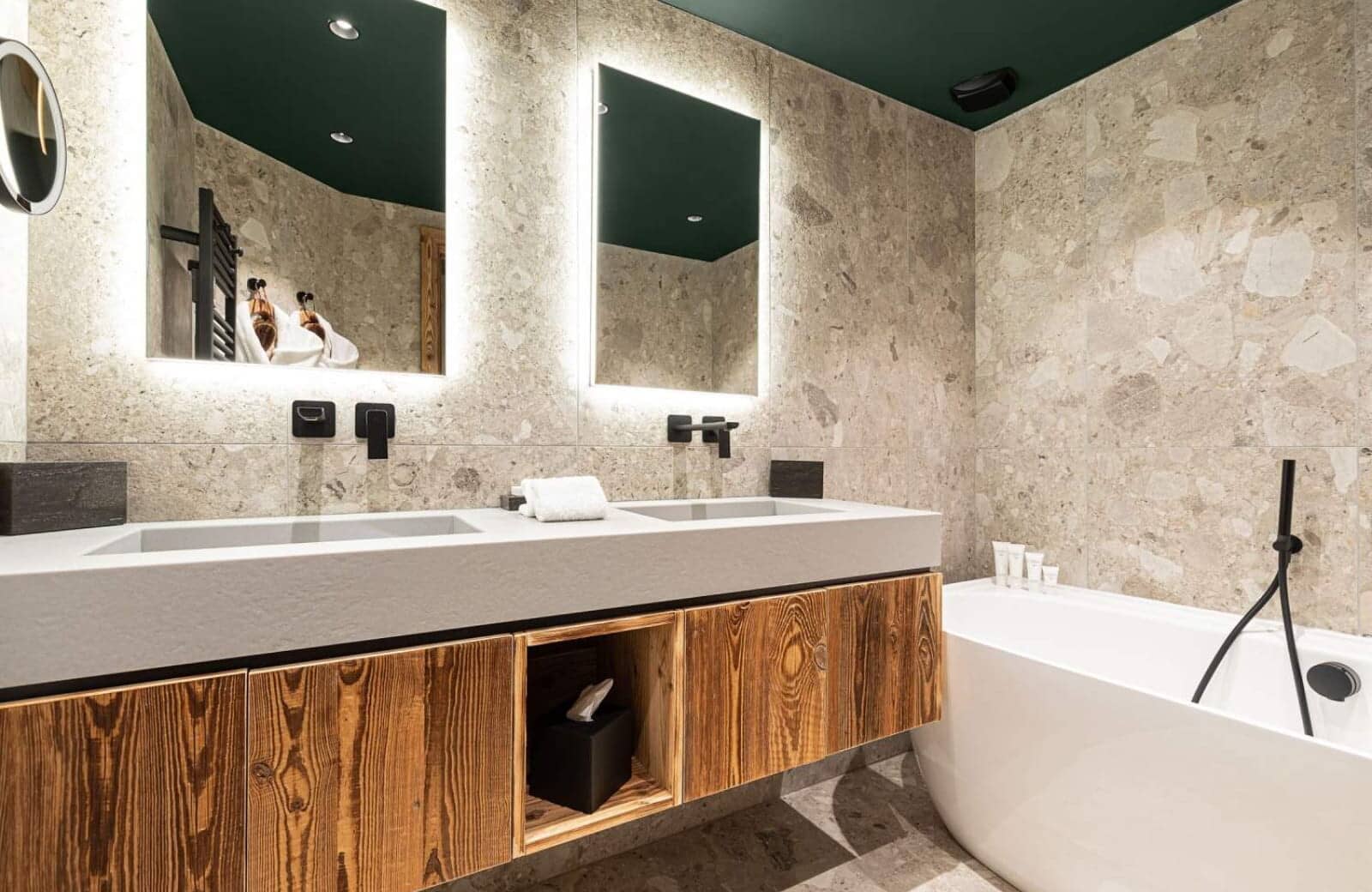 Bathroom with dual vanity, backlit mirrors, and soaking tub