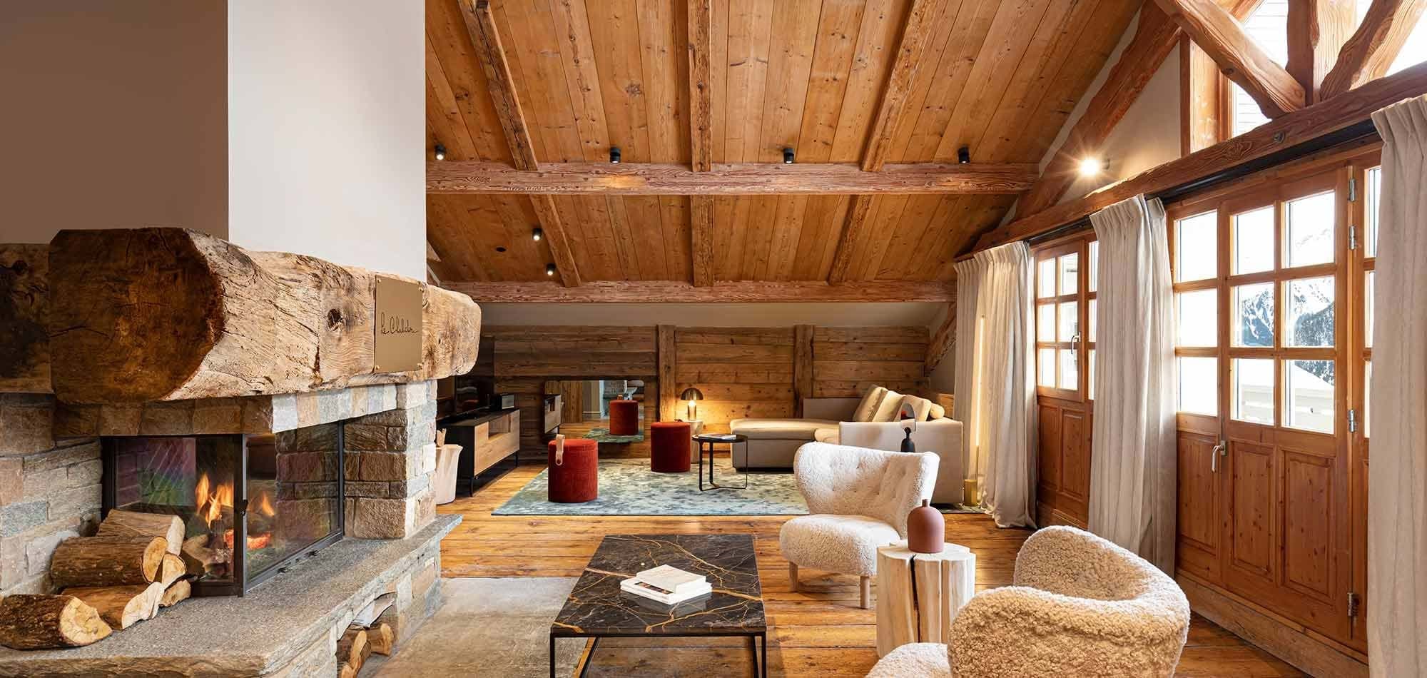 Living area with wood-burning fireplace and mountain views through French doors