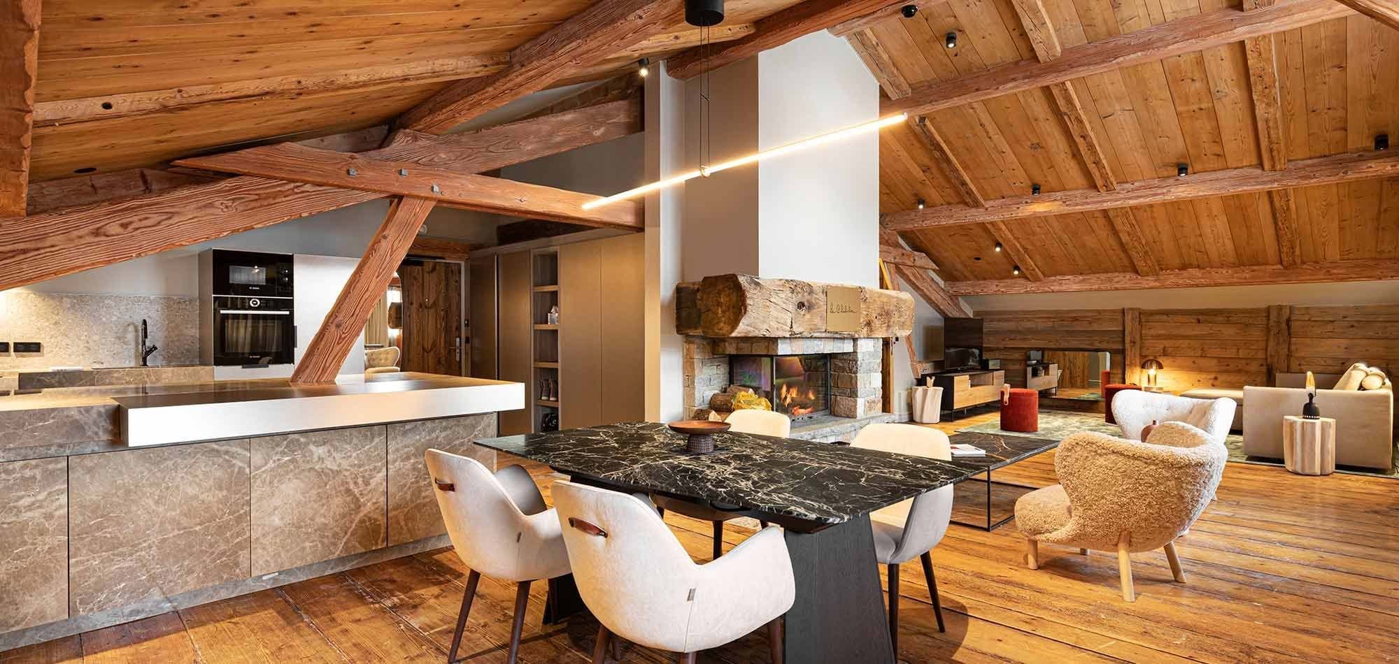 Open-plan dining and living area with wood-burning fireplace and marble island