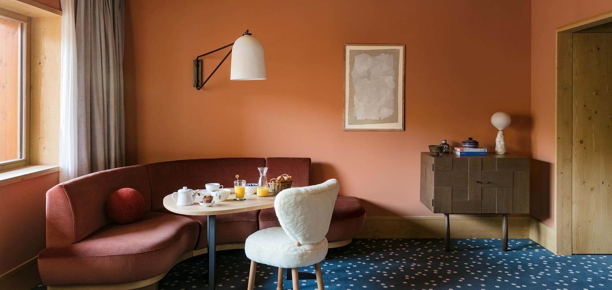 Dining nook with curved banquette seating and swing-arm wall sconce