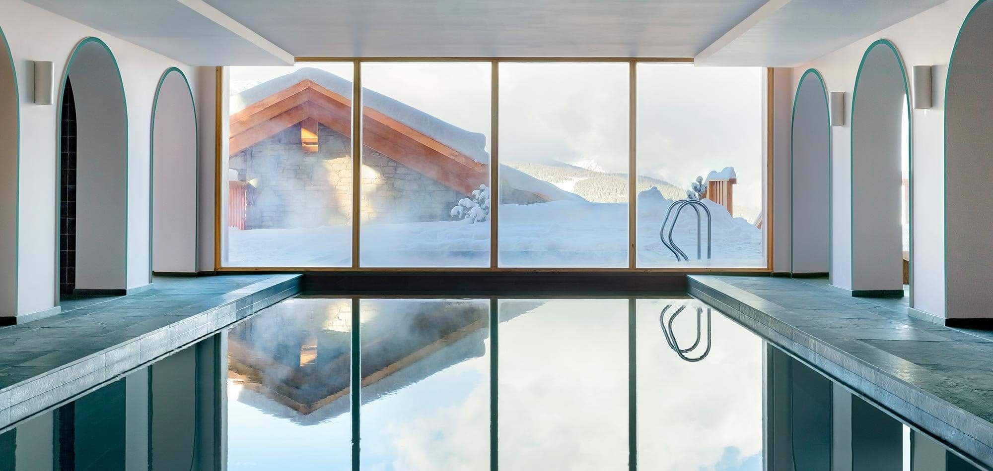Heated indoor pool with floor-to-ceiling mountain views