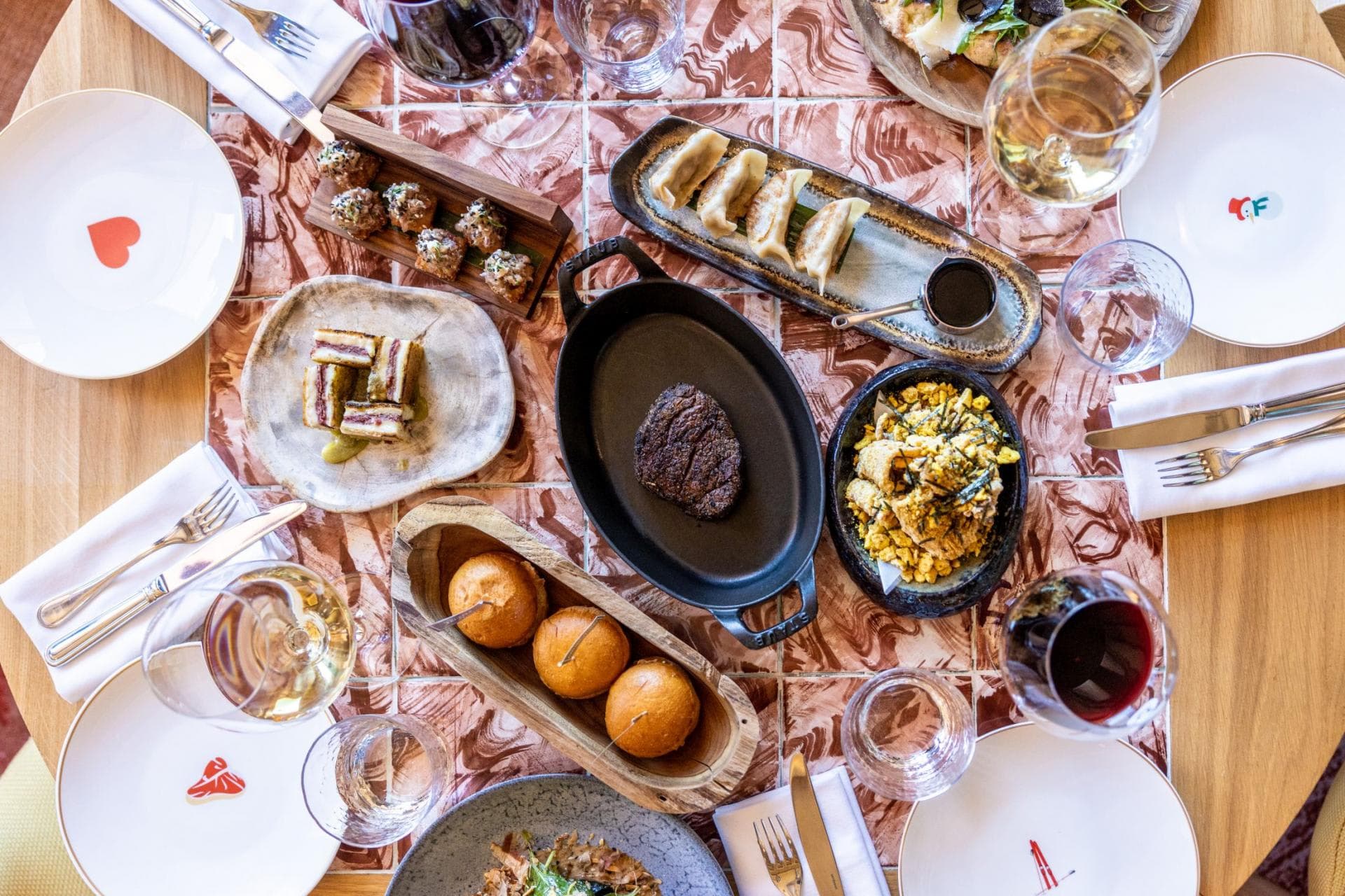 Dining table featuring marbled tile inlay and custom ceramic dinnerware