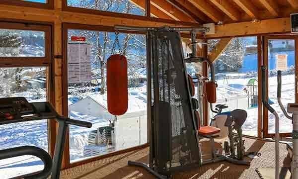 Fitness room with universal gym, punching bag, and snowy mountain views