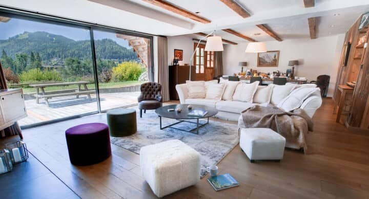Open living area with sectional seating and floor-to-ceiling mountain views