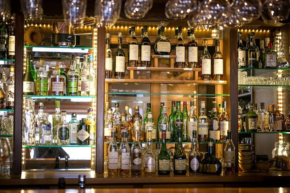 Custom wet bar with backlit glass shelving and extensive spirits collection