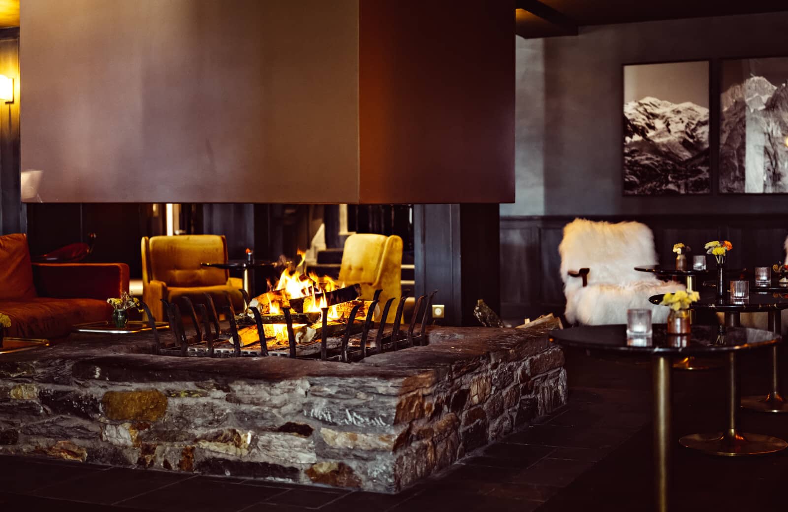 Stone fire pit lounge with 360-degree wood-burning fireplace and armchair seating