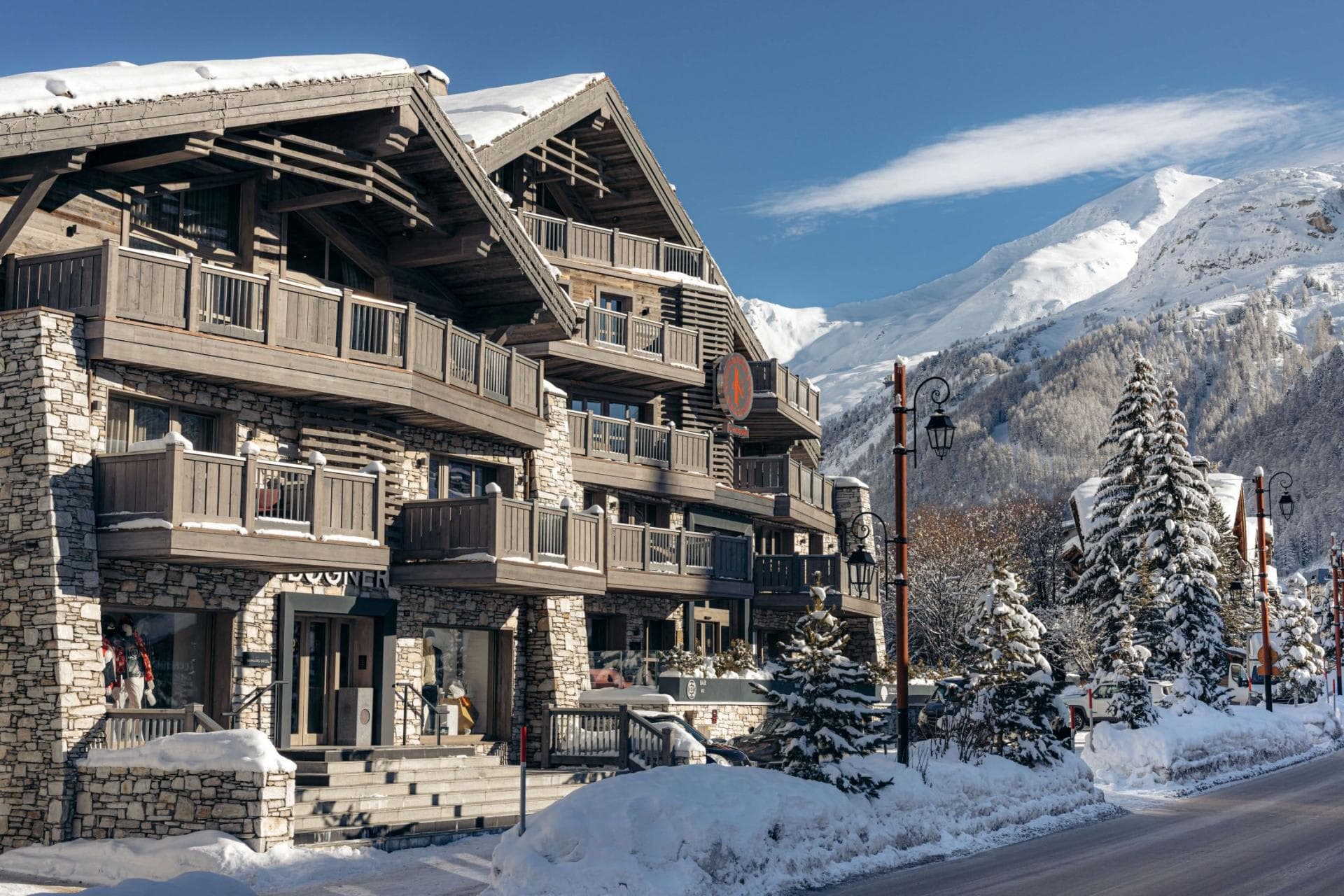 Chalet exterior with ground-floor boutique and private balconies facing mountain peaks