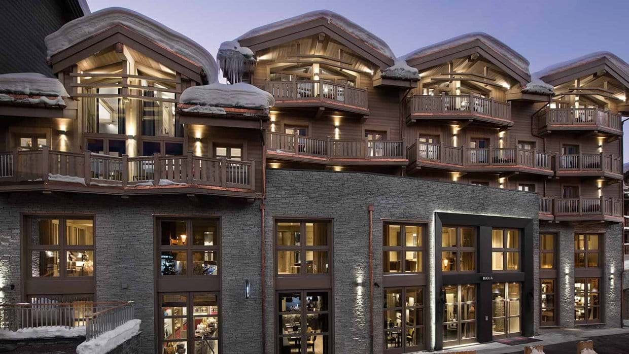 Mountain lodge exterior with private balconies and stone facade