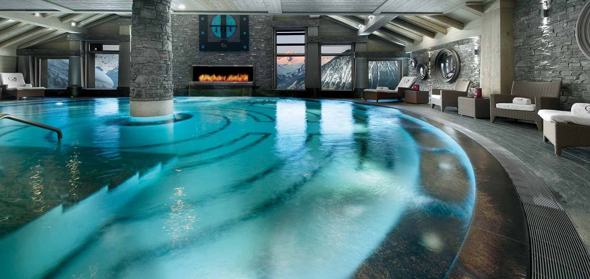 Indoor heated pool with mountain views and linear fireplace