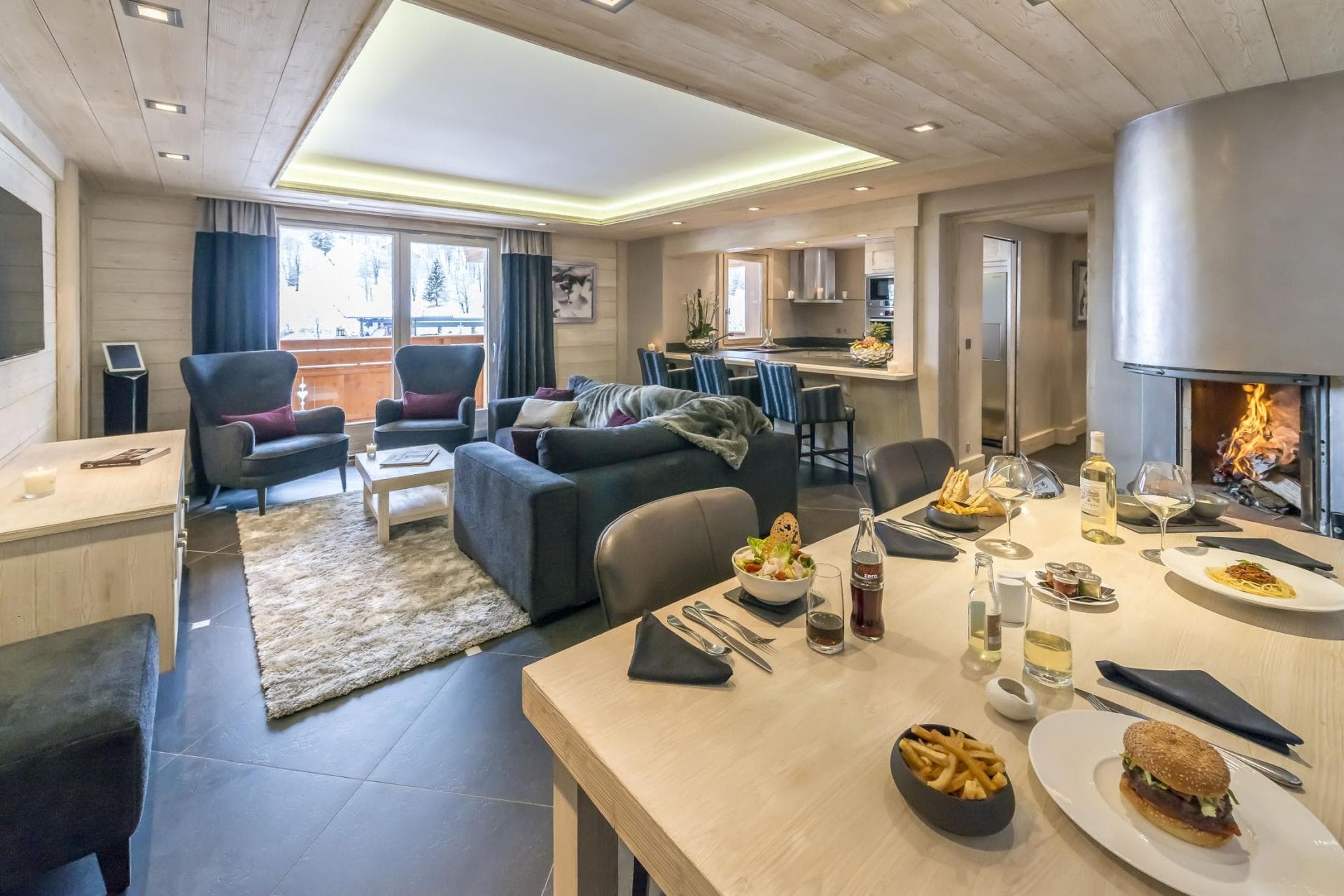 Open-plan living area with wood-burning fireplace and breakfast bar seating