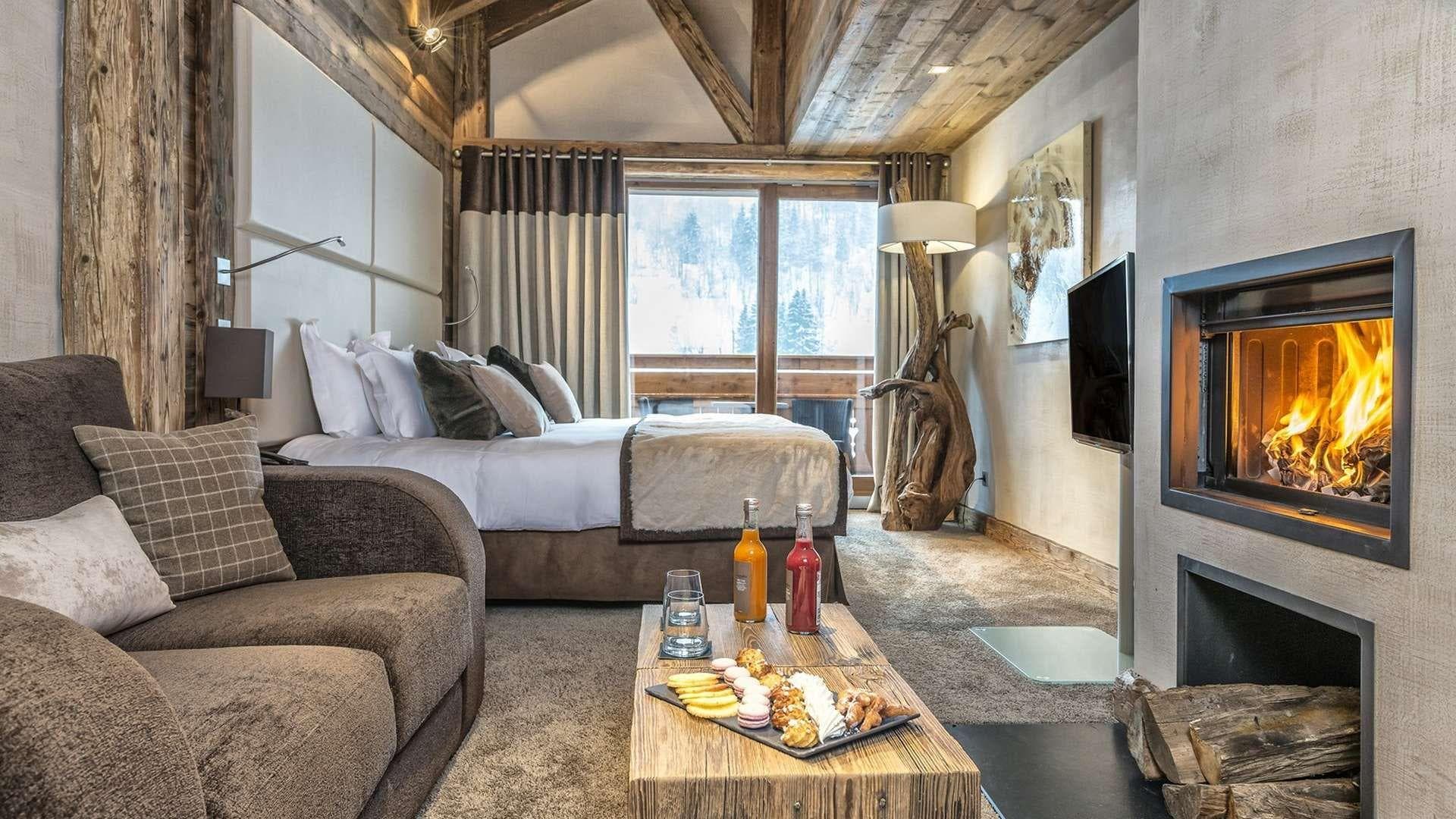 Primary bedroom with gas fireplace, king bed, and private balcony access