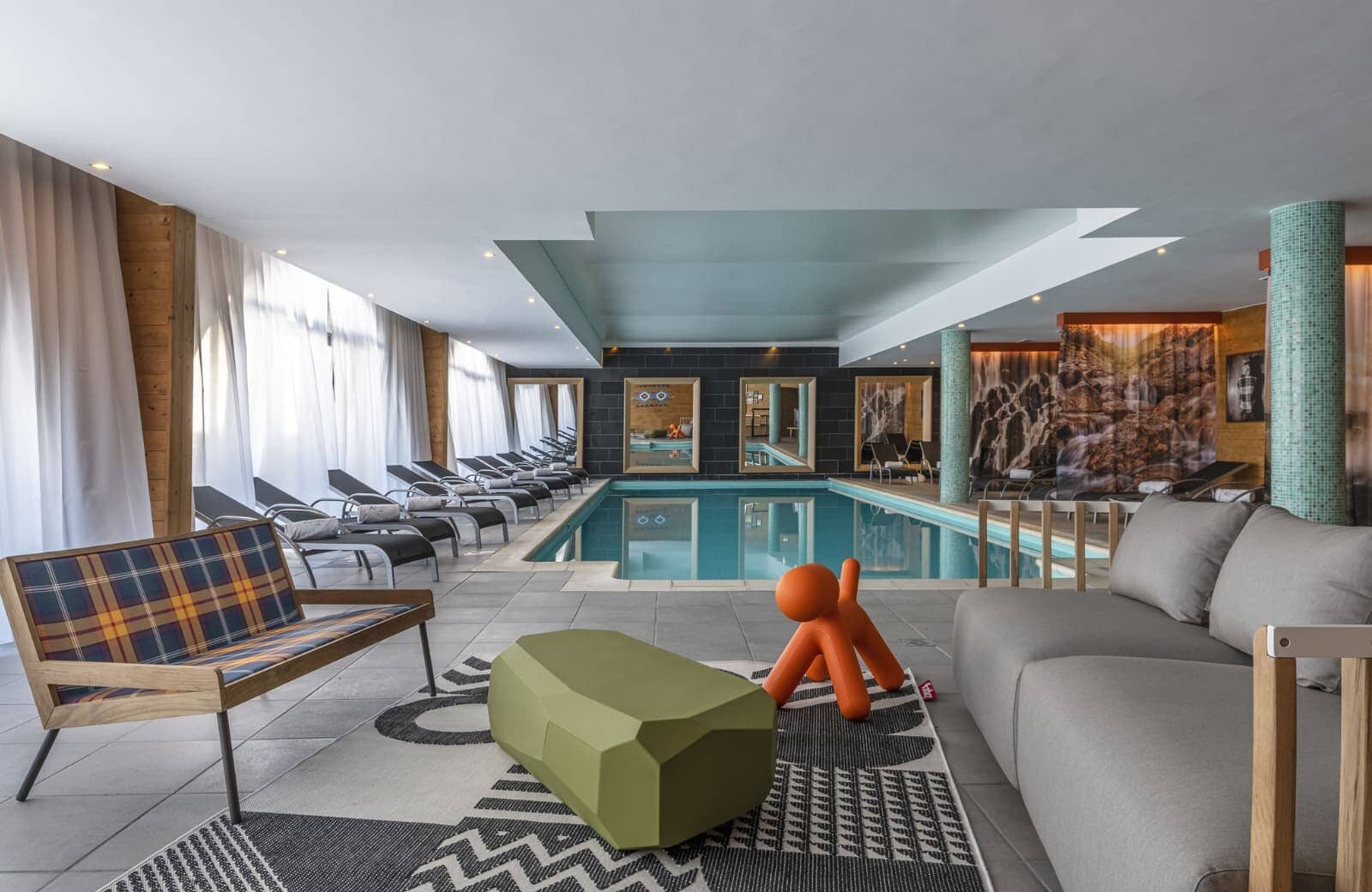 Indoor heated pool with lounge seating and adjacent relaxation area
