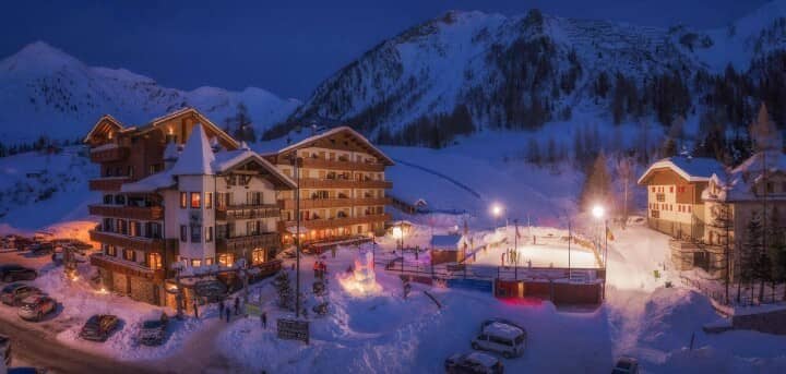 Ski resort exterior with lighted ice rink and mountain views
