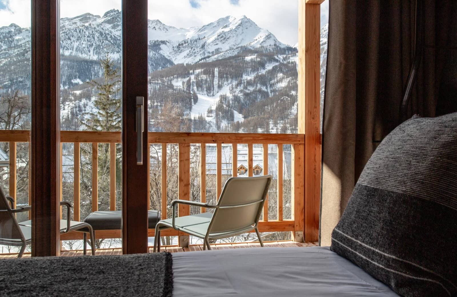Bedroom balcony with seating overlooking mountain peaks and ski slopes