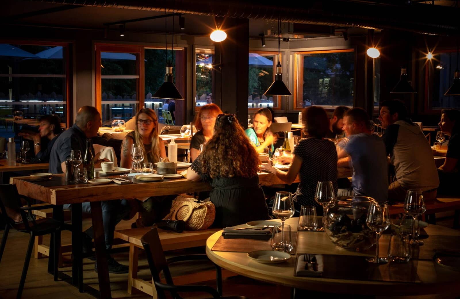 Communal dining area with long tables and outdoor terrace access