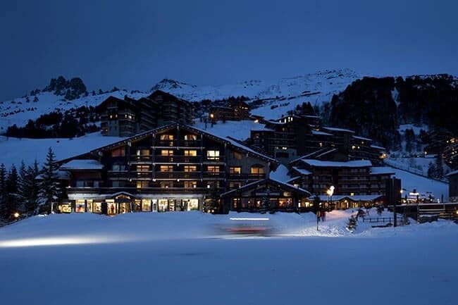 Ski-in, ski-out resort exterior with ground-floor shops and mountain views