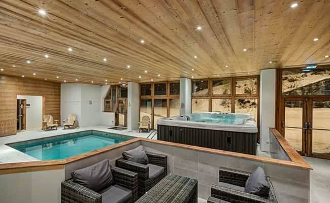 Indoor spa area with heated pool, hot tub, and sauna
