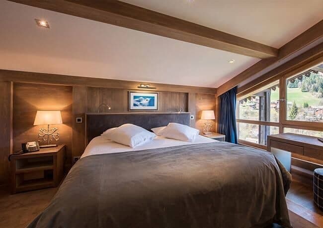Bedroom with king bed, reading lights, and mountain valley views