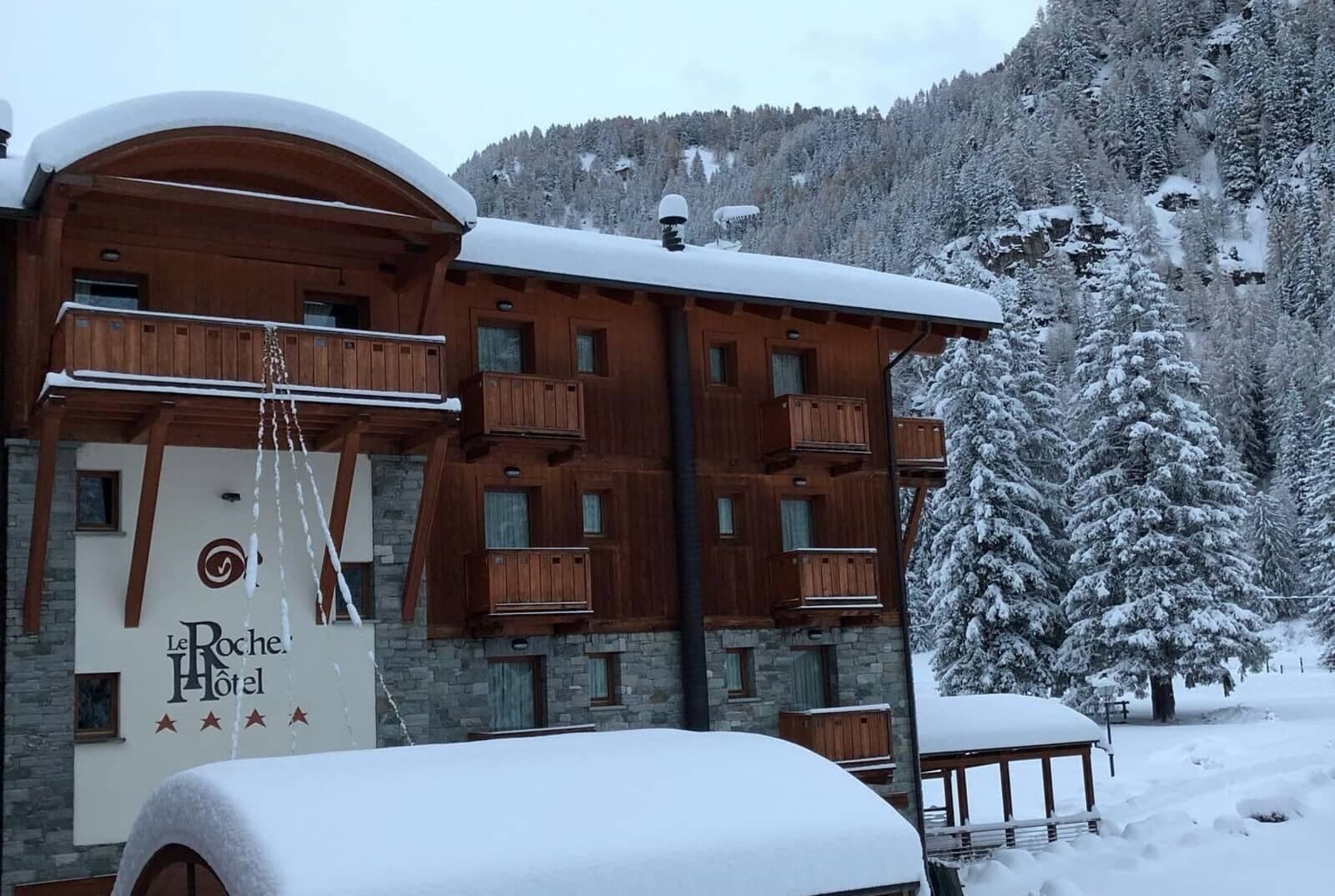 Chalet-style hotel exterior with private balconies and forest views