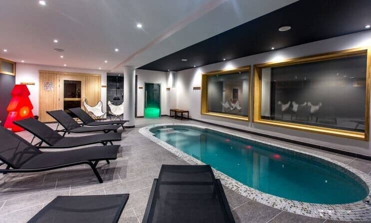 Indoor pool area with five loungers and wooden sauna