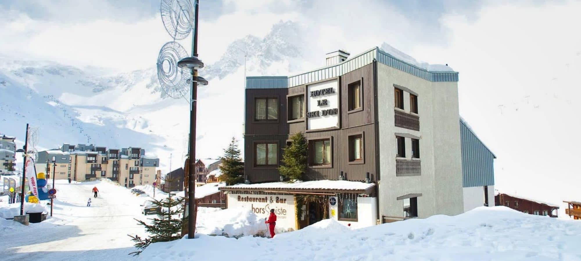 Ski-in/ski-out hotel exterior with on-site restaurant and mountain backdrop