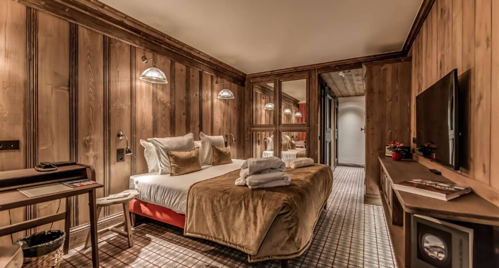 Guest bedroom with king bed, writing desk, and mirror-fronted wardrobes