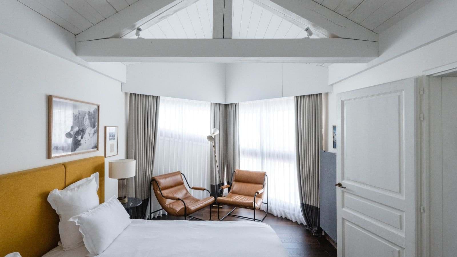 Bedroom with vaulted wood ceilings and leather armchair seating nook