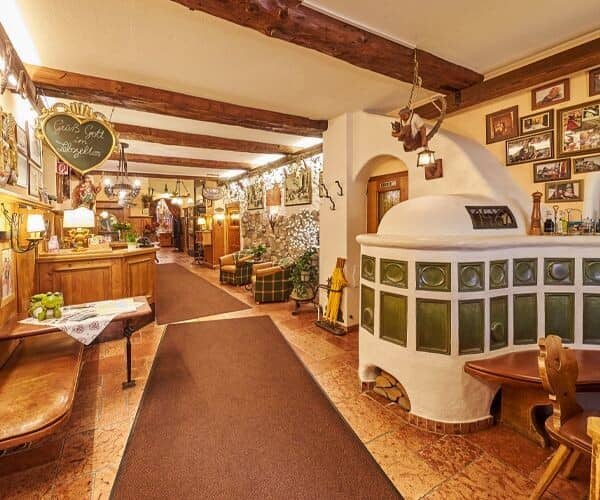 Lobby area featuring traditional Kachelofen tile stove and exposed ceiling beams