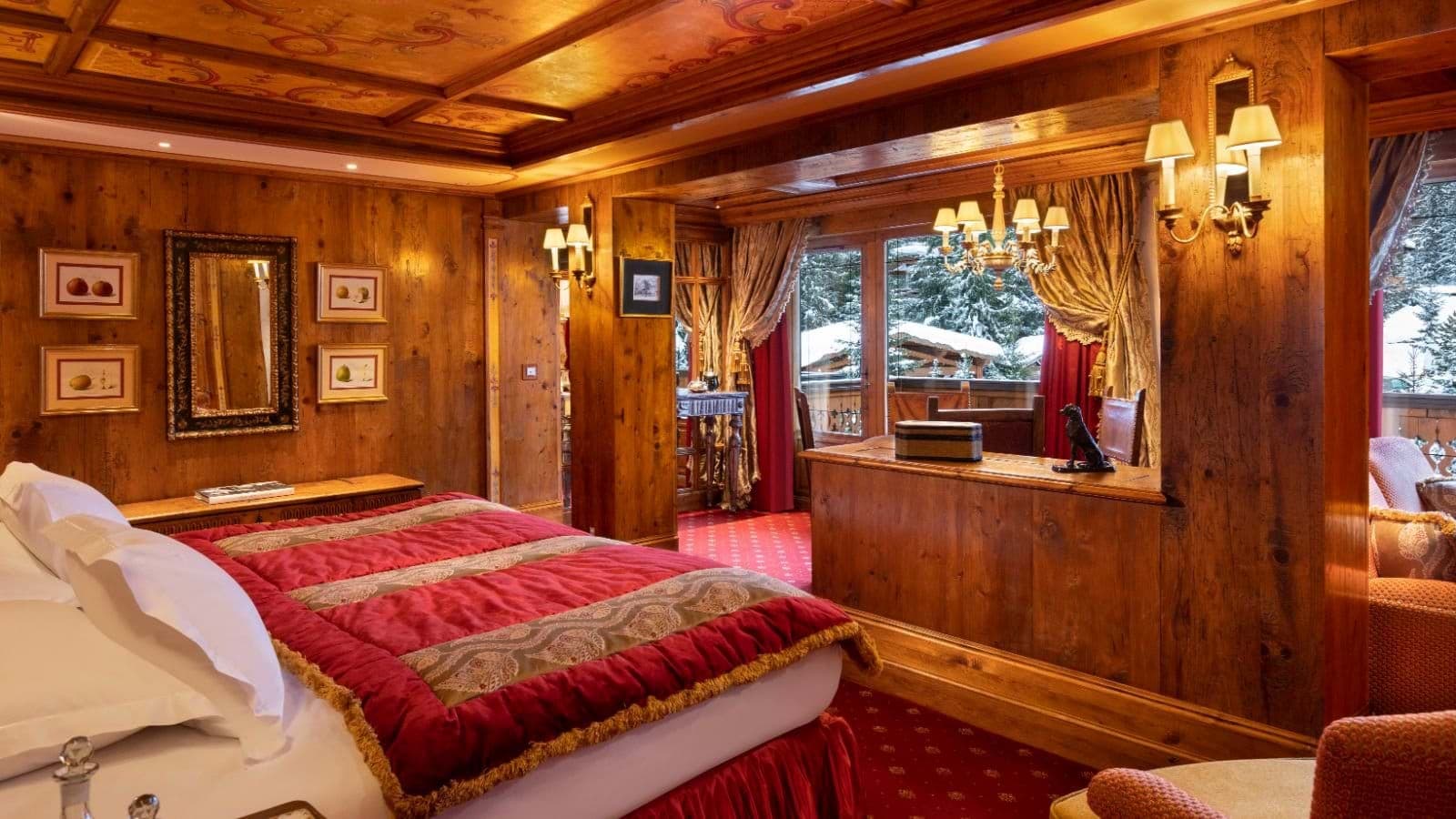 King bedroom with hand-painted wood ceiling and desk with snowy view