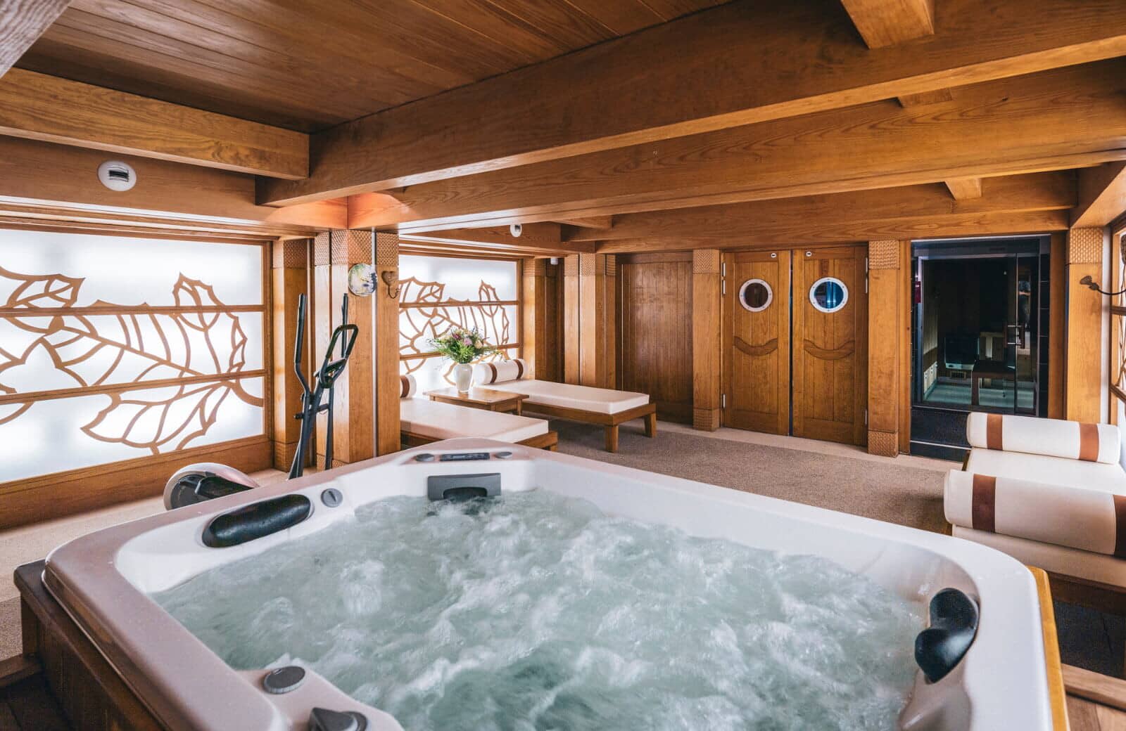 Indoor spa area with hot tub, sauna access, and elliptical trainer
