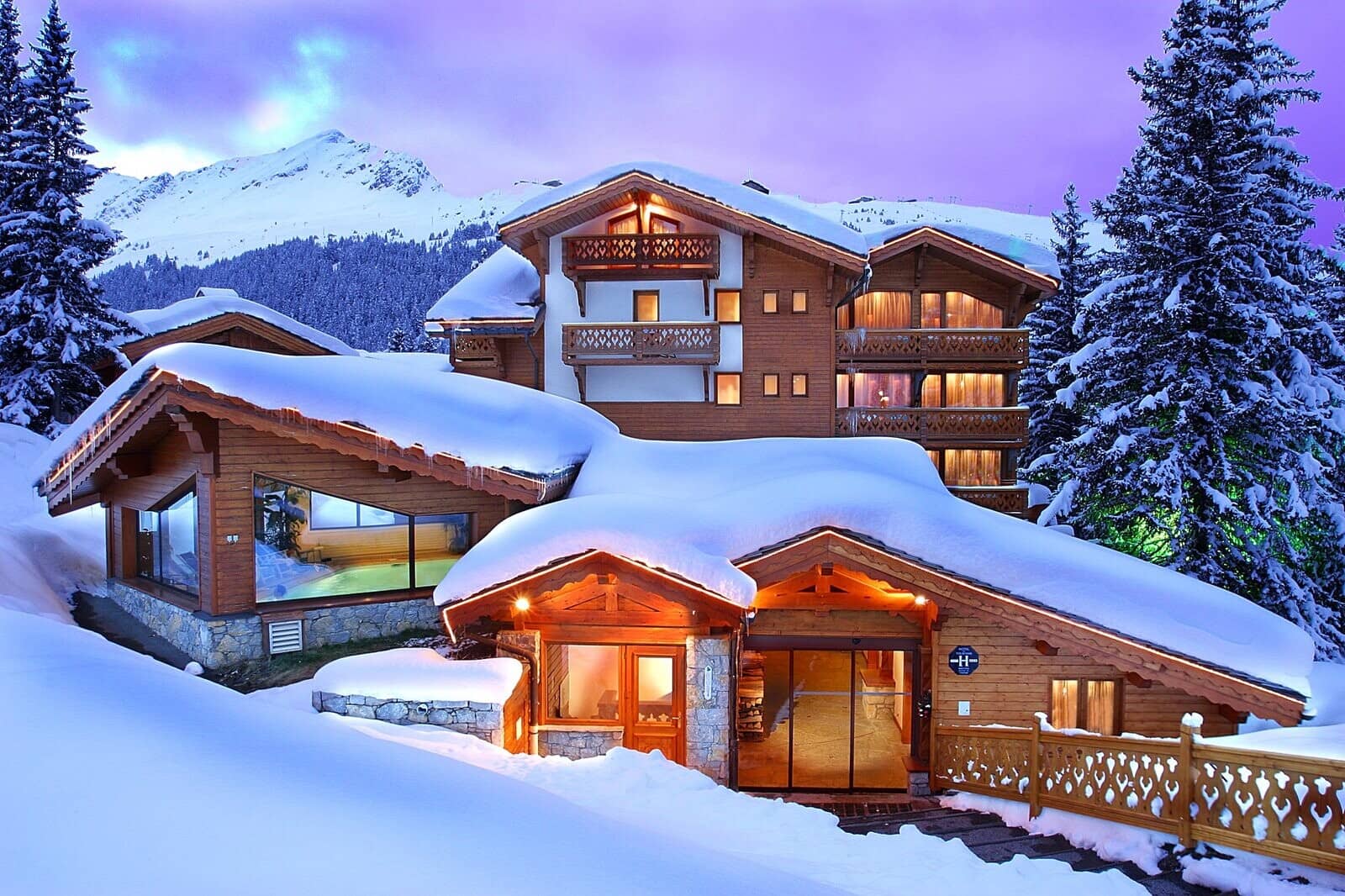 Ski-in chalet exterior with indoor heated pool and mountain views