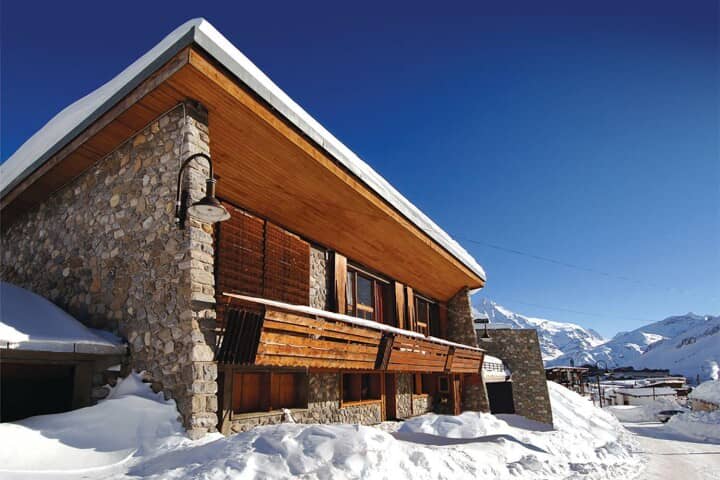 Stone and timber chalet exterior with private balcony and mountain views