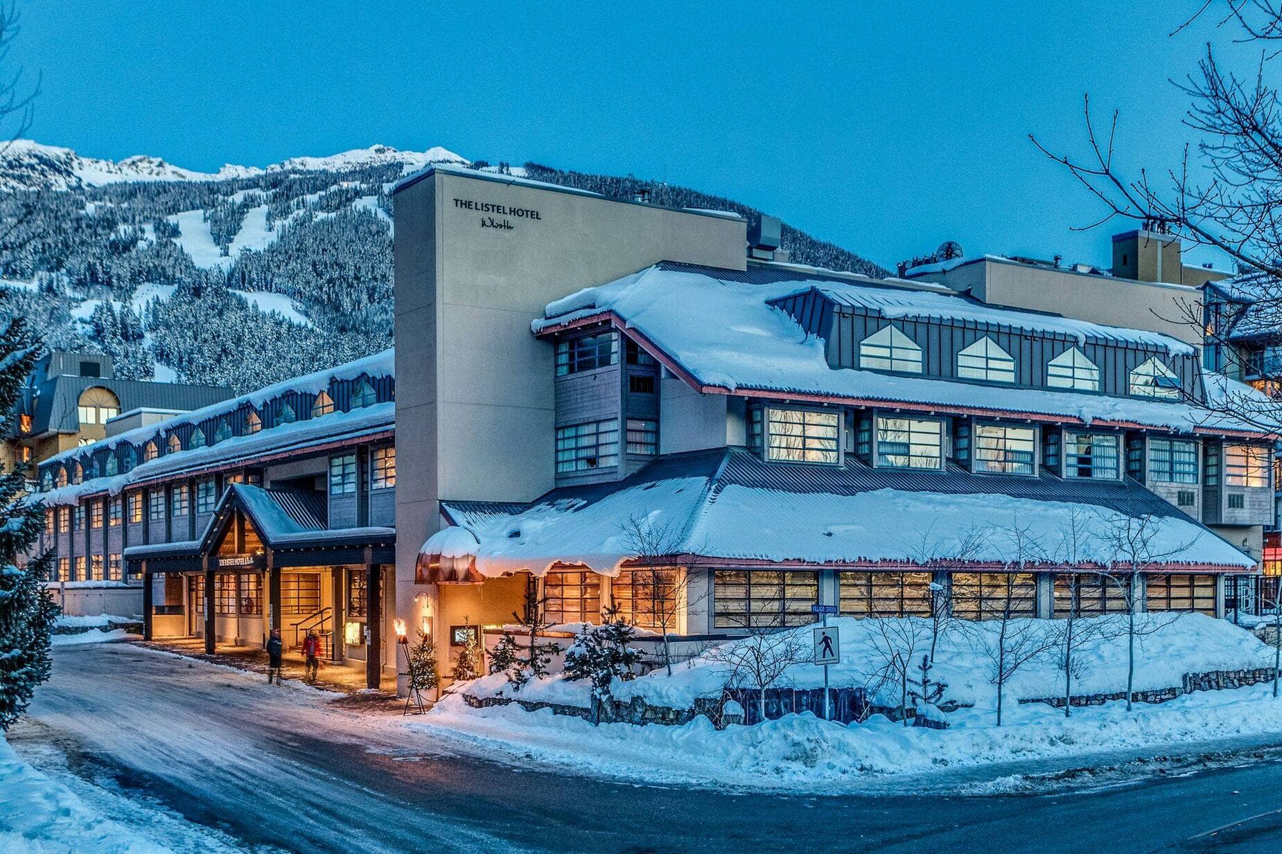 Hotel exterior with heated entryway and mountain ski run views
