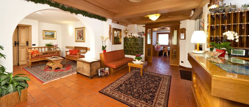 Reception desk with key rack and lounge seating with traditional tiled stove