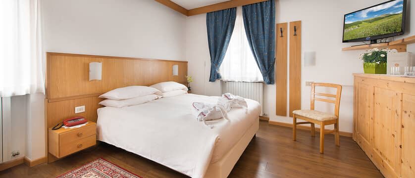 Bedroom with king bed, wall-mounted television, and integrated wood furniture