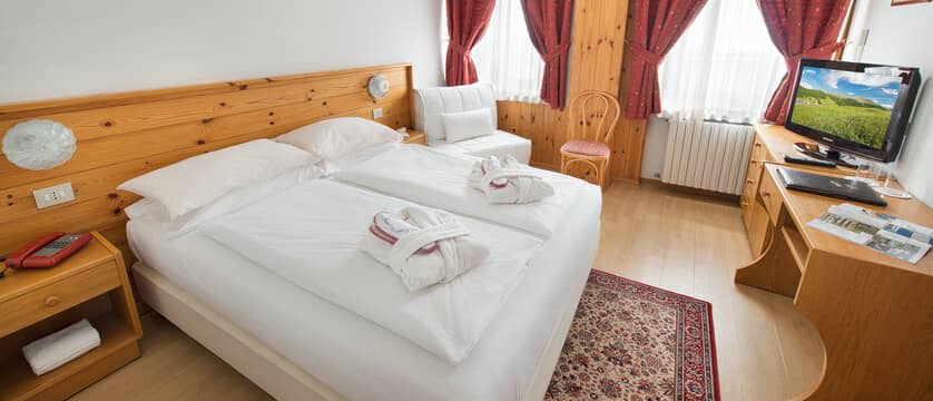 Bedroom with twin beds, dedicated desk space, and armchair seating