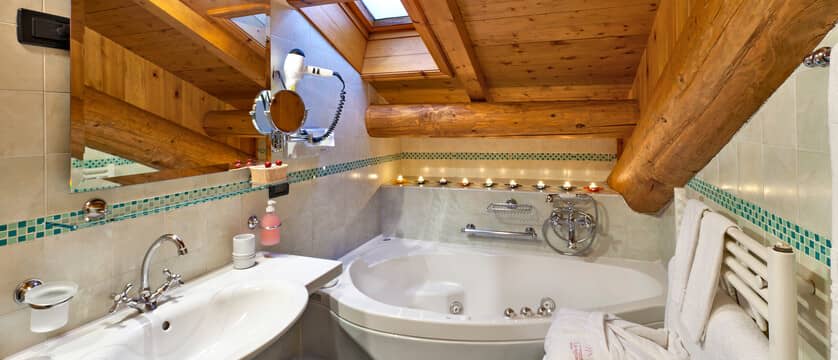 Bathroom with corner jetted tub, skylight, and heated towel rack