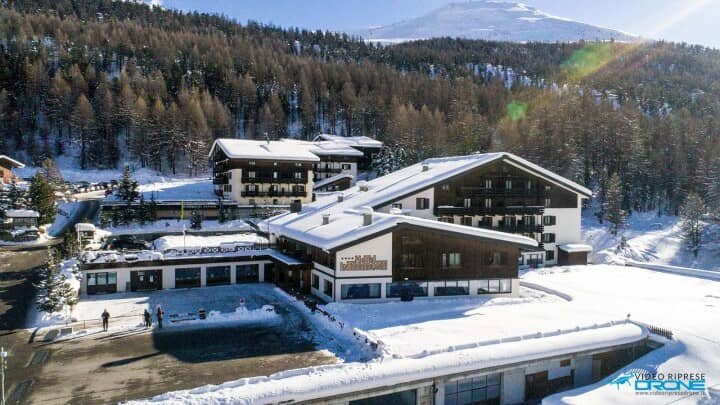 Exterior view of hotel complex with snow-covered mountain backdrop