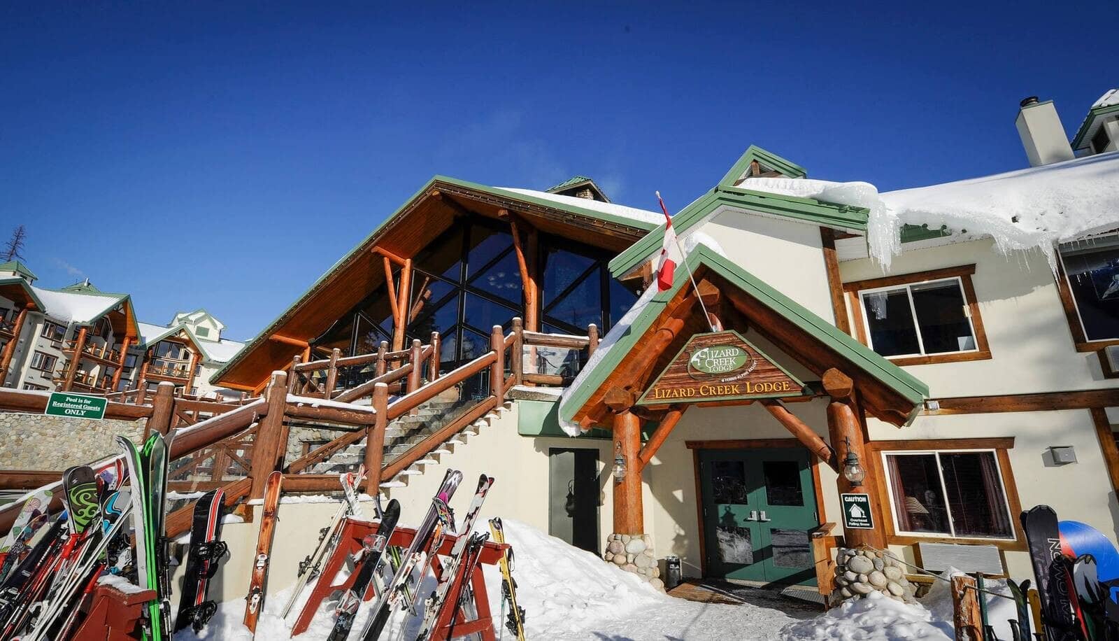 Ski-in lodge entrance with outdoor ski racks and stone stairs