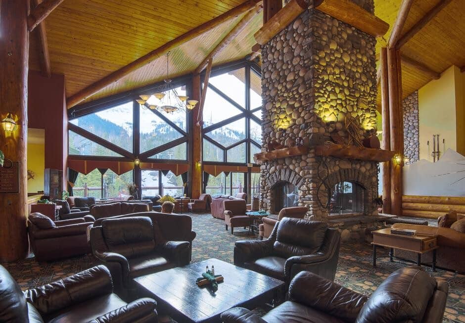 Lodge lounge with river stone fireplace and ski mountain views