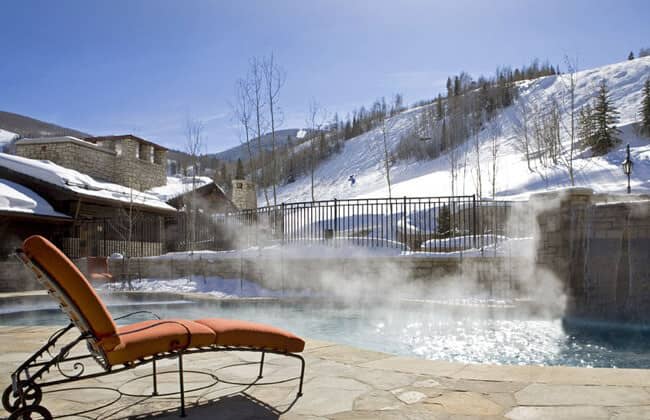 Heated outdoor pool and lounge area with direct ski slope views