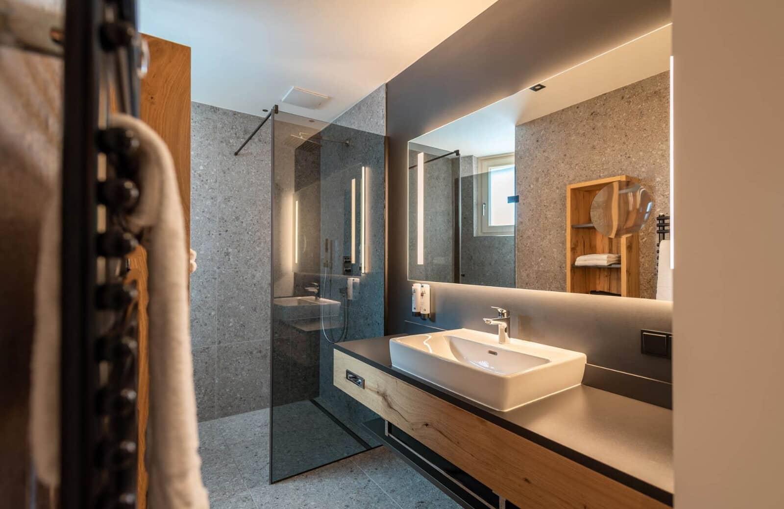 Bathroom featuring walk-in rainfall shower and vanity with heated towel rail