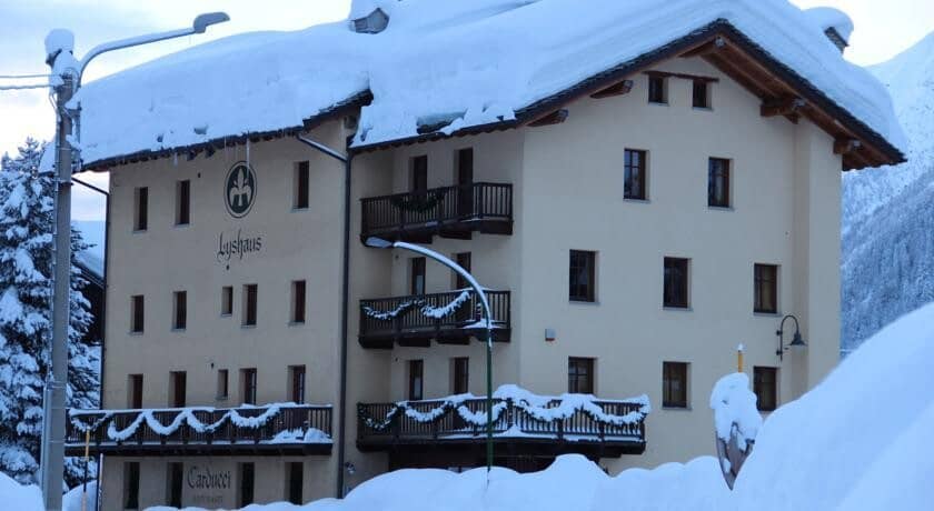 Chalet exterior with private balconies and snow-covered mountain backdrop