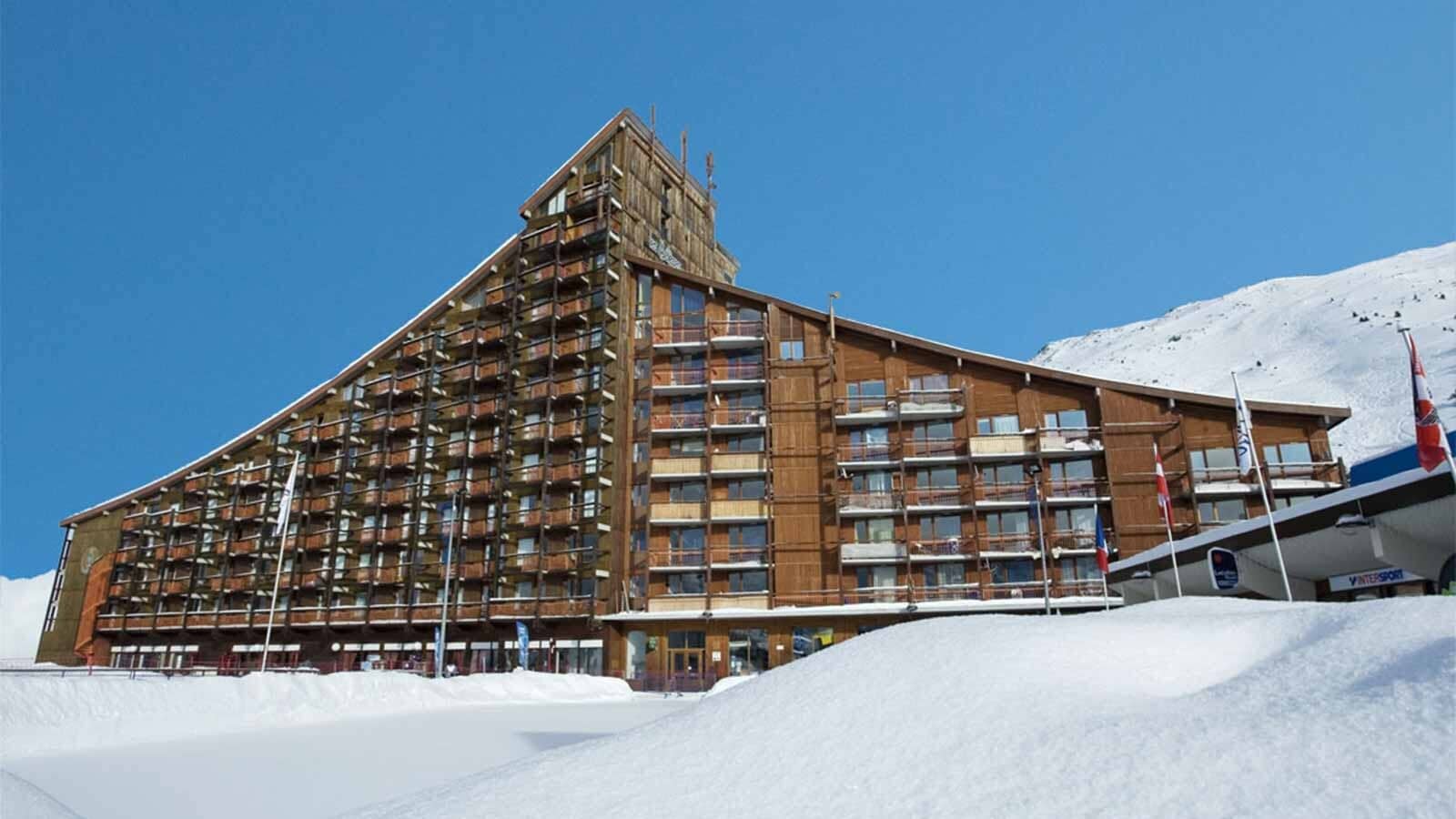Timber-clad apartment building with private balconies and direct slope access